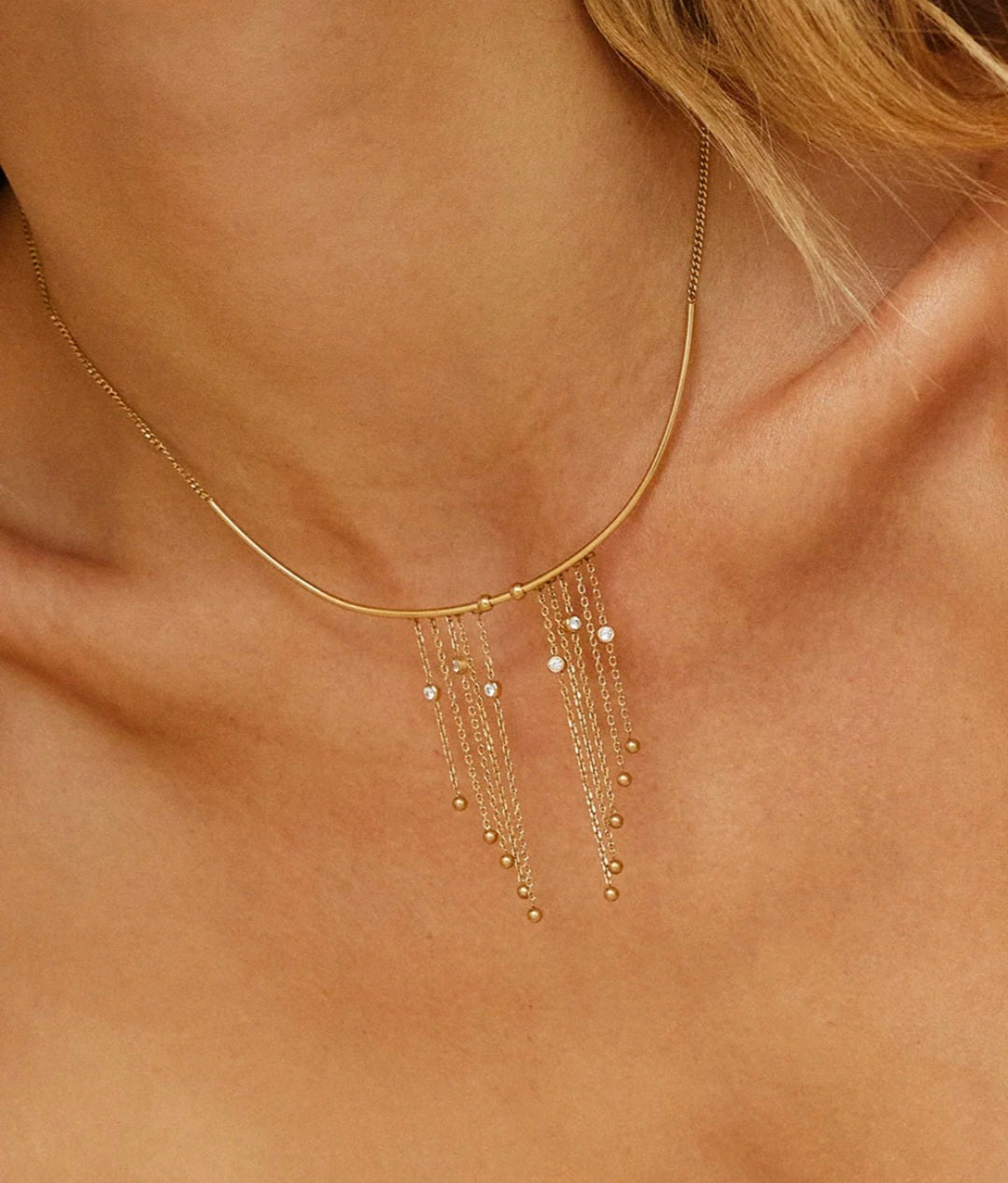 Collana dorata con frange e zirconi